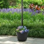 Shows a flower arrangement that is planted in a solar lamp post light with a planter base - techgoodandbad.com