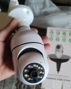 Use a light bulb security camera to update you home security. This image shows a person holding a light bulb camera with an open package in the background. With easy installation and seamless integration with your existing light fixtures, this camera provides discreet and effective monitoring of your home.