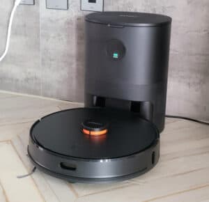 Experience the convenience of smart home automation with this smart vacuum cleaner! This image shows a smart vacuum cleaner docked on its base in the kitchen, highlighting the advances in smart home automation.